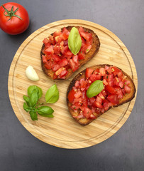 Classic italian Bruschetta, appetizer. Bruschetta with chopped tomatoes, basil, toasted white bread slices and olive oil.