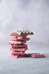 Broken pink Ruby chocolate bar pieces, made from ruby cocoa beans with gold, silver and white crisp
