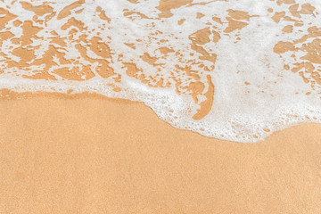 Shallow frothy waves against beautiful clear fine yellow sand.