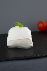 Large mozzarella with a blackened slate board.