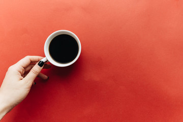 Cup of black coffee and cotton flowers on dark background 