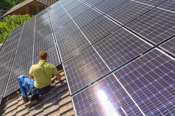 Installing solar photovoltaic panel system. Solar panel technician installing solar panels on roof....