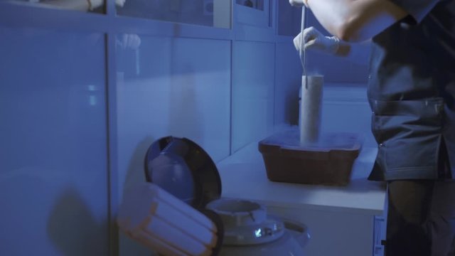 Specialist Embryologist Takes a capsule With Embryos from the Cryobank
