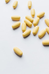 Scatterded yellow pills on white background 