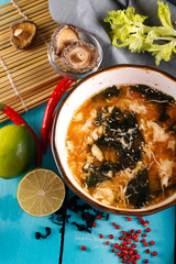 portion of Japanese soup with shiitake mushrooms, tofu and green onions close-up in a bowl on the table.