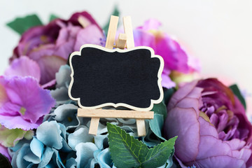 A small black Board for greeting notes and an important date on a beautiful bouquet of flowers