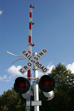 Railroad crossing sign against blue sky