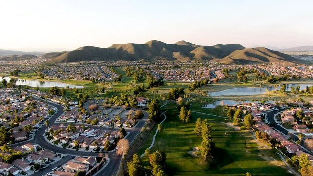 Aerial view of golf course surrounded by town houses and luxury villas during sunset time. Temecula, California, USA
