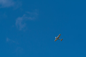 Small airplane in flying in high in a blue sky.