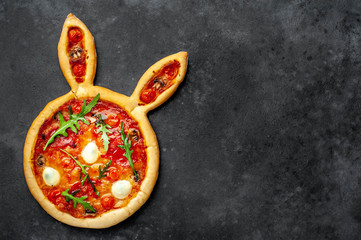 Easter pizza in the form of a hare with eggs on a stone background with copy space for your text