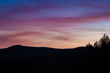 Obraz premium Silhouettes of trees against the sunset sky
