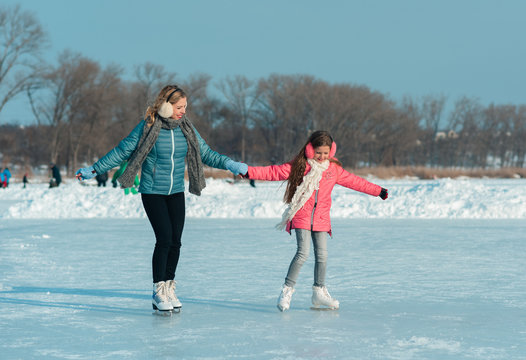 Young family enjoying a day out the ice area in a snowy park