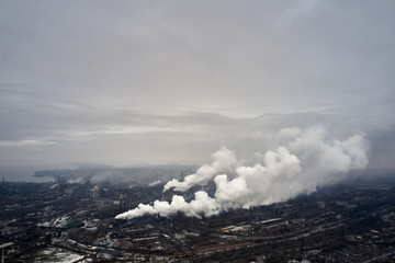 Fototapeta premium Aerial view of factory pipes throwing hazardous emissions into the air.