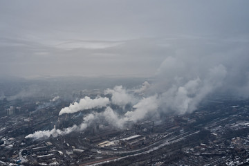 Aerial view of factory pipes throwing hazardous emissions into the air.