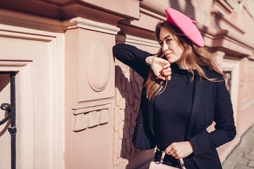 Female beauty, fashion. Stylish woman wearing pink beret holding purse outdoors. Spring clothes, accessories.