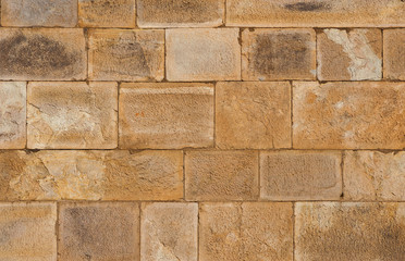Old brownish stone block wall as background