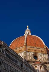 Fototapeta na wymiar St Mary of the Flower iconic dome in Florence seen from below, built by italian architect Brunelleschi in the 15th century and symbol of Renaissance in the world (with copy space above)