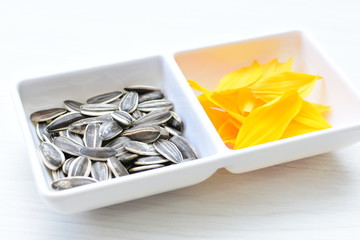 Helianthus annuus: Fresh sunflower seeds, with sunflower flower petals
