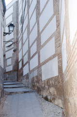 narrow old street on slope and a lamppost in the city of Granada