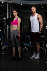 Fototapeta na wymiar Young Couple Doing Heavy Weight Exercise For Biceps