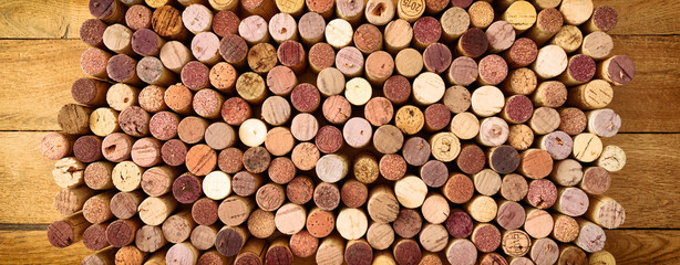 Very high resolution photo of standing red wines used corks arranged in rows and columns on wooden rustic background. All specific terms were removed.