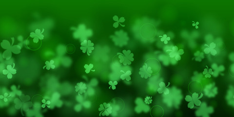 Background on St. Patrick's Day made of blurry clover leaves in green colors with seamless horizontal repetition