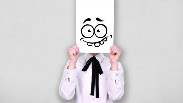 portrait, teenager holds white paper sheet with loony smiley drawing, animation, covering face. emotions, Imagination, creativity, successful idea concept.