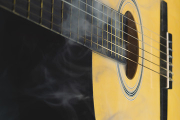 Acoustic guitar in smoke close up. musical instrument. strings on the guitar neck