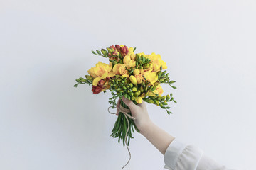 girl holding yellow freesia flower bouquet with white background 
