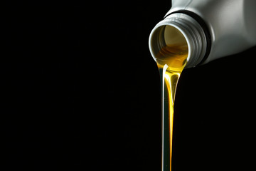Pouring car oil on dark background