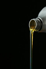 Pouring car oil on dark background