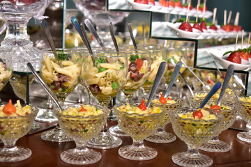 Obraz na płótnie Canvas small portions of food pasta, salad, olive oil, spices in glass cups with blurs in the photo