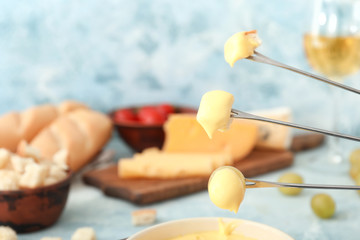 Croutons and grape dipped into cheese fondue, closeup