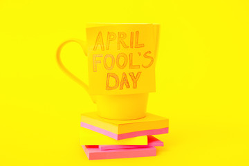 Papers with cup on color background. April Fool's Day prank