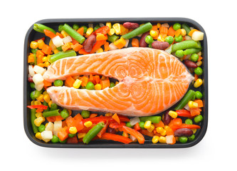 Baking dish with raw salmon steak and vegetables on white background