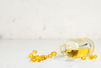 Bottle of fish oil and pills on white background