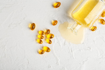 Bottle of fish oil and pills on white background