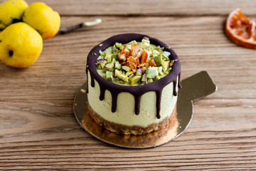 cake with fruit and nuts. Raw healthy dessert. Orange cake with chocolate. Wooden background