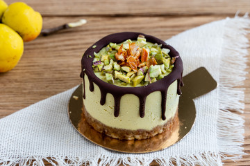 cake with fruit and nuts. Raw healthy dessert. Orange cake with chocolate. Wooden background