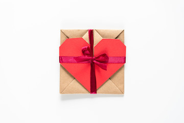 Hart shaped paper gift card tied with red ribbon on the white background top high angle view