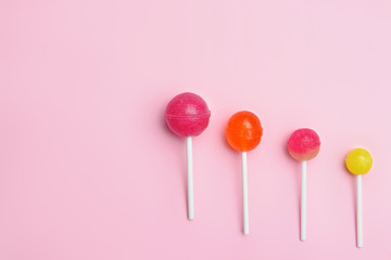 Tasty lollipops on color background