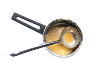 Dirty empty saucepan with ladle on white background