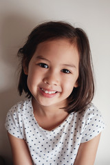 Portrait of happy mixed race child, young Asian japanese kid girl smiling