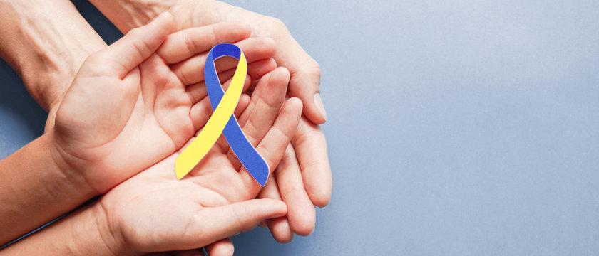 Adult and child hands holding blue and yellow ribbon shaped paper, Down syndrome awareness , World down syndrome day - Powered by Adobe