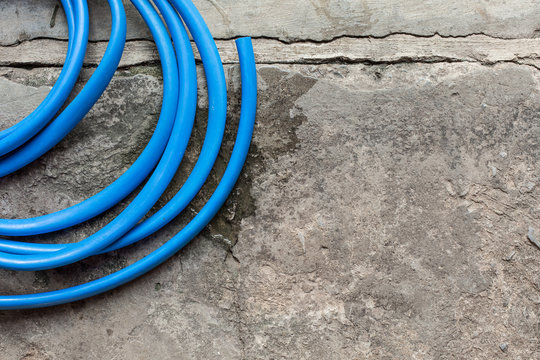 Blue water hose on concrete floor  and copy space