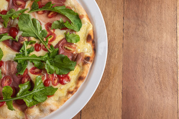 Pizza on the brown wooden table