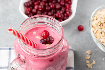 Freshly homemade smoothie with cranberries, oatmeal and yogurt in a mug jar on a gray table. Healthy eating concept, close up