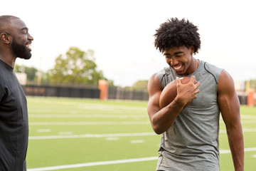 American Football coach training a young athlete.