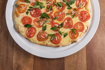 Pizza on the brown wooden table