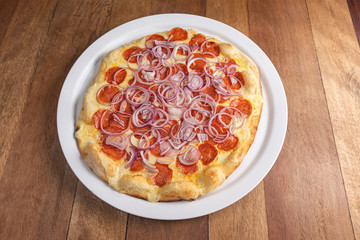 Pizza on the brown wooden table